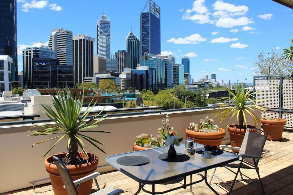 Terrace with plants and outdoor dining table. Terrace looking over incredible view of the city. 