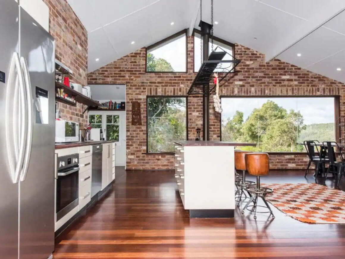 Large kitchen area in Airbnb. Brick internal wall and wooden floor. 