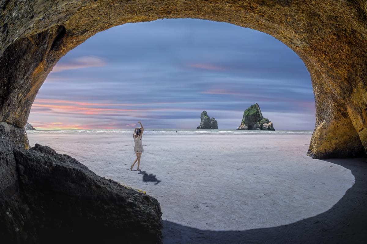 Woman at Wharariki Beach while on a self-drive in South Island's Golden Bay