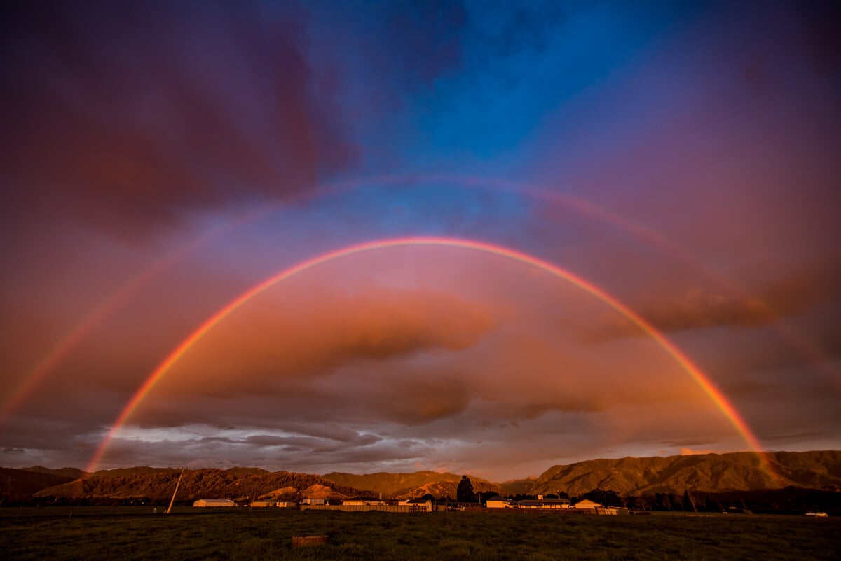 Double rainbow and sunset over Karamea on New Zealand's West Coast