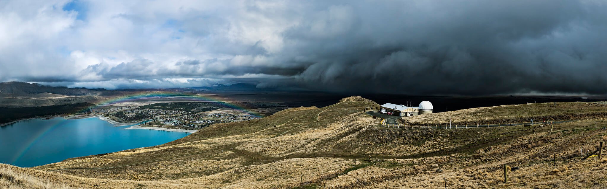 A storm cloud brewing over Lake Tekapo, a famous place to visit in New Zealand.