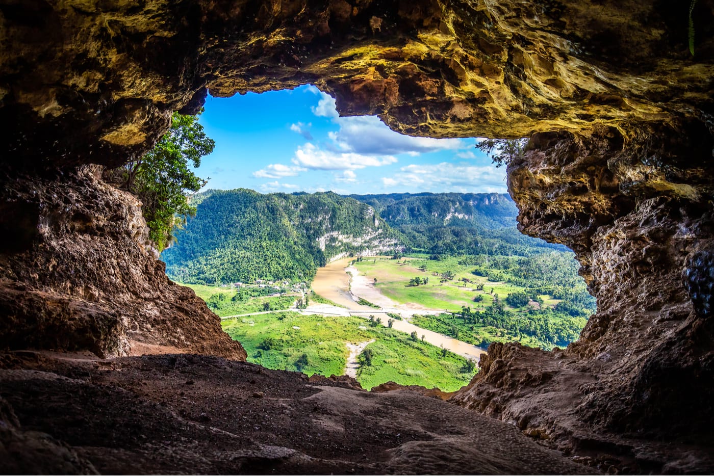view from a cave looking down below on a lush green mountainous landscape in Arecibo, Puerto Rico