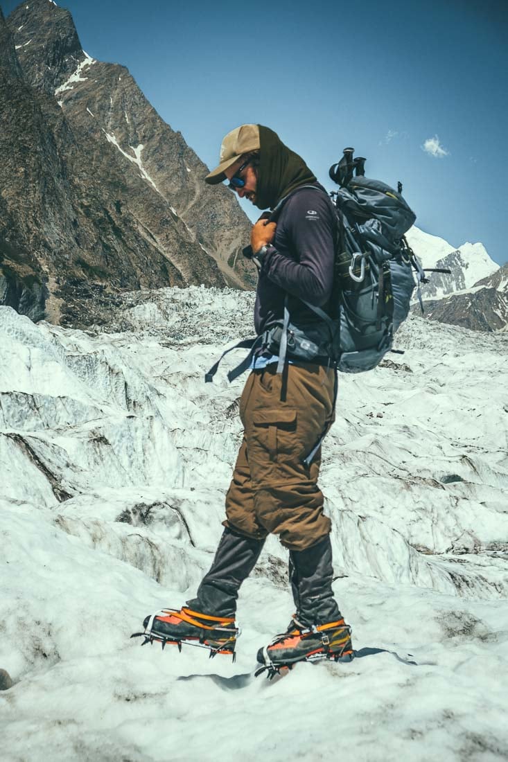A person high in the mountains in Pakistan wearing crampons hiking and climbing
