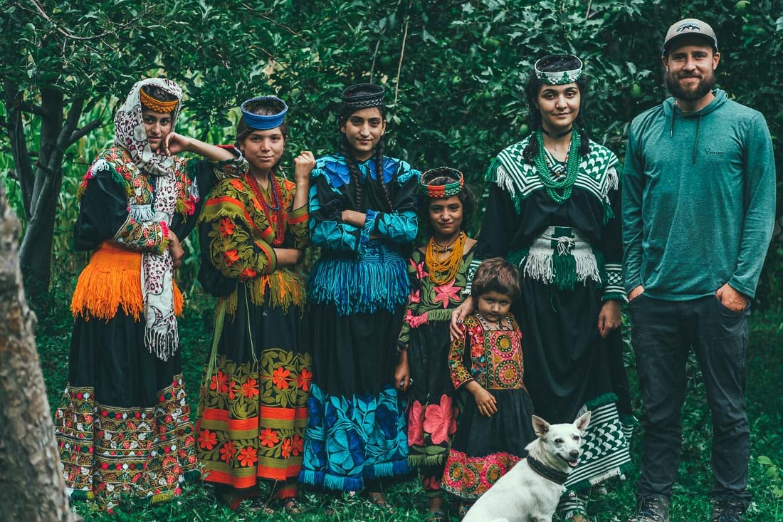 A backpacker in Pakistan hangs out with local women in the Kalash Valley