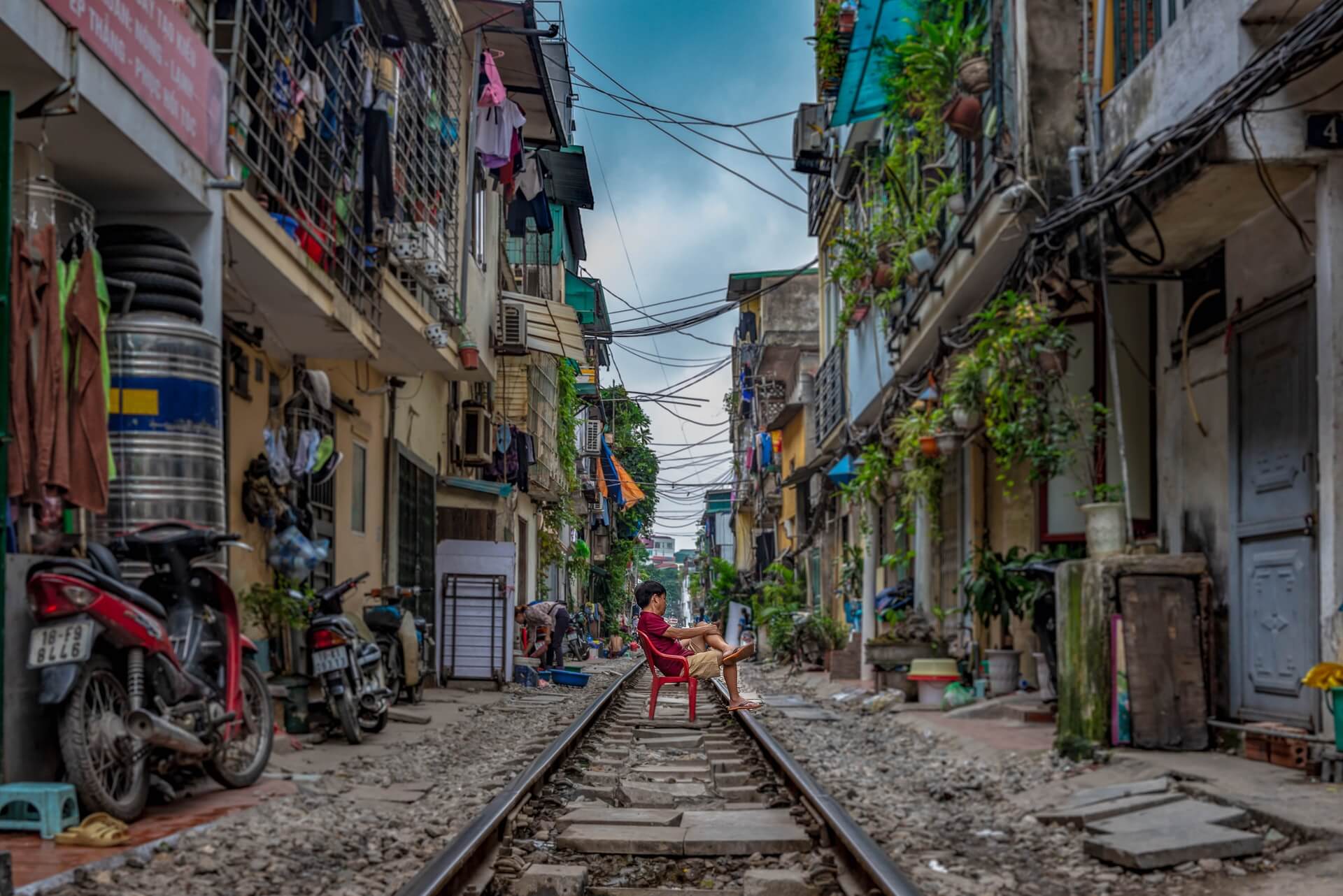 Boy sitting on the train tracks running through the Old Quarter in Hanoi