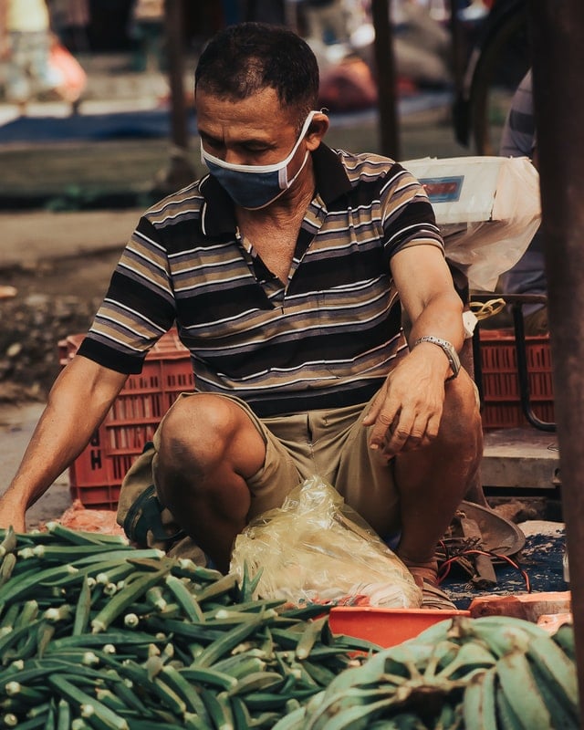 A man selling vegetables at a local street market in Nepal