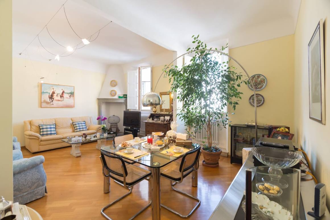 Living area in Airbnb. Colourful, cosy with plants, sofas and a small dining table.