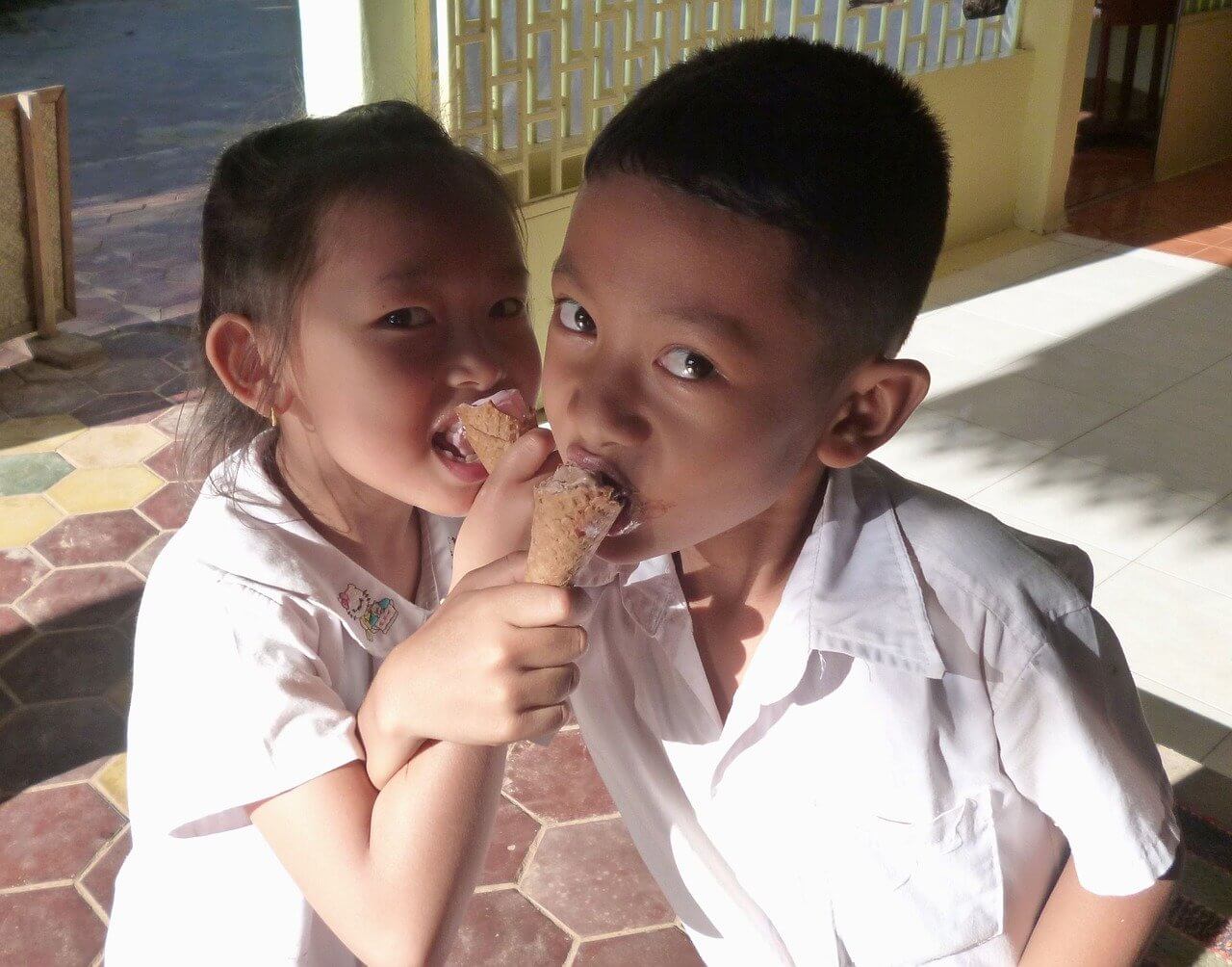 Two schoolkids in Cambodia eating ice-cream after their English lesson