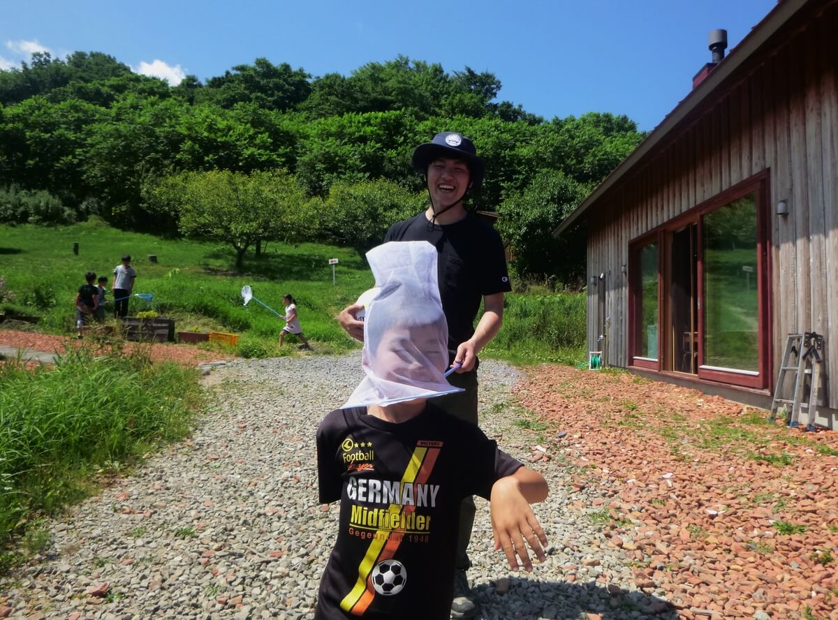 A volunteer at an eco-project in Hokkaido plays with the children