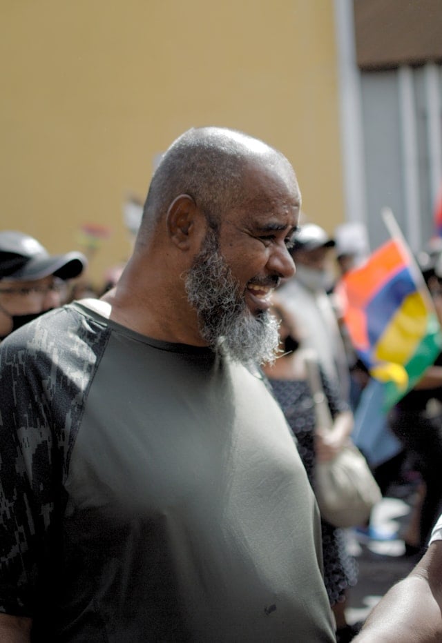 A Mauritian man at a demonstration in Port Louis smiling widely