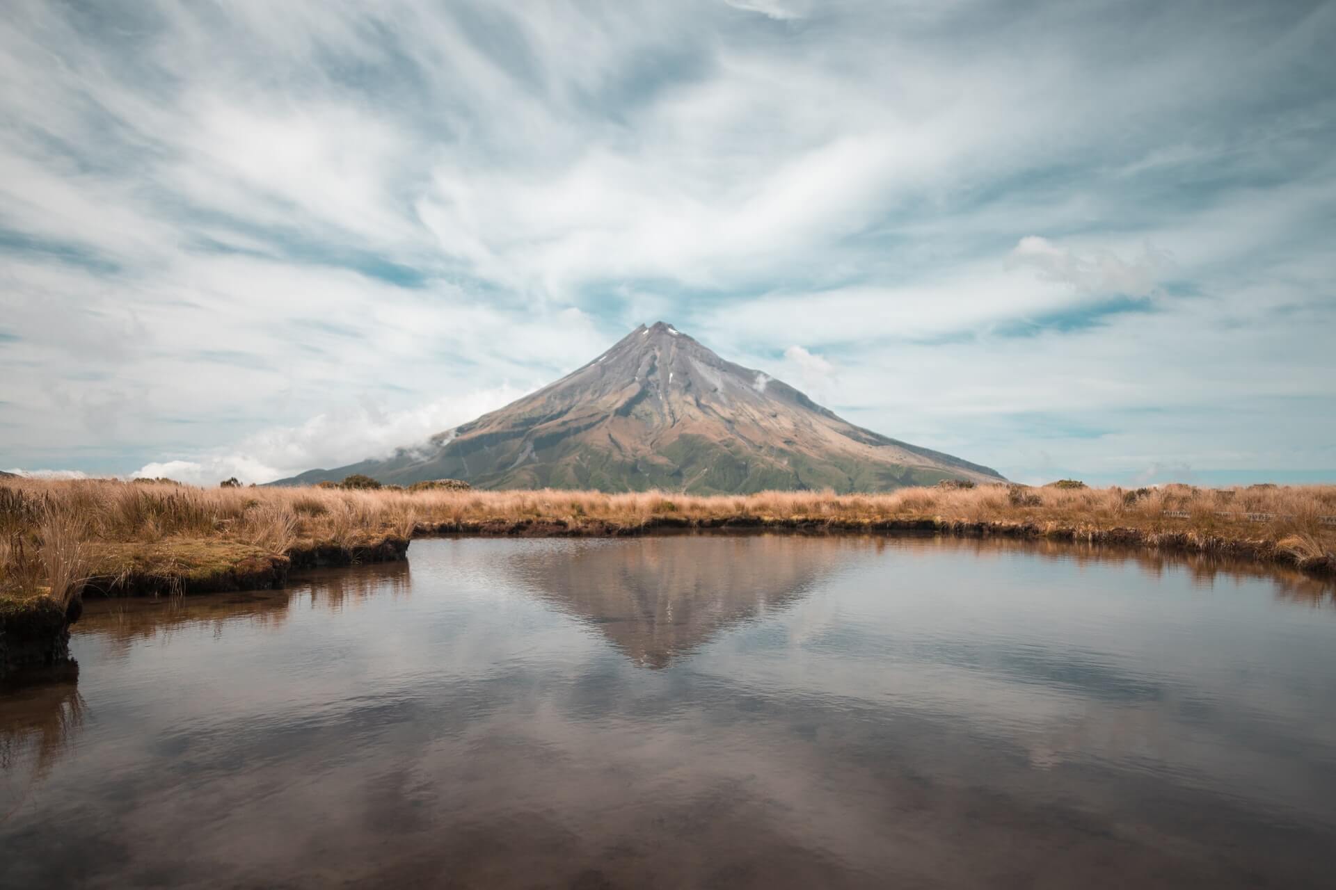 Mount Taranaki reflected in a lake - spectacular hiking place to visit in New Zealand