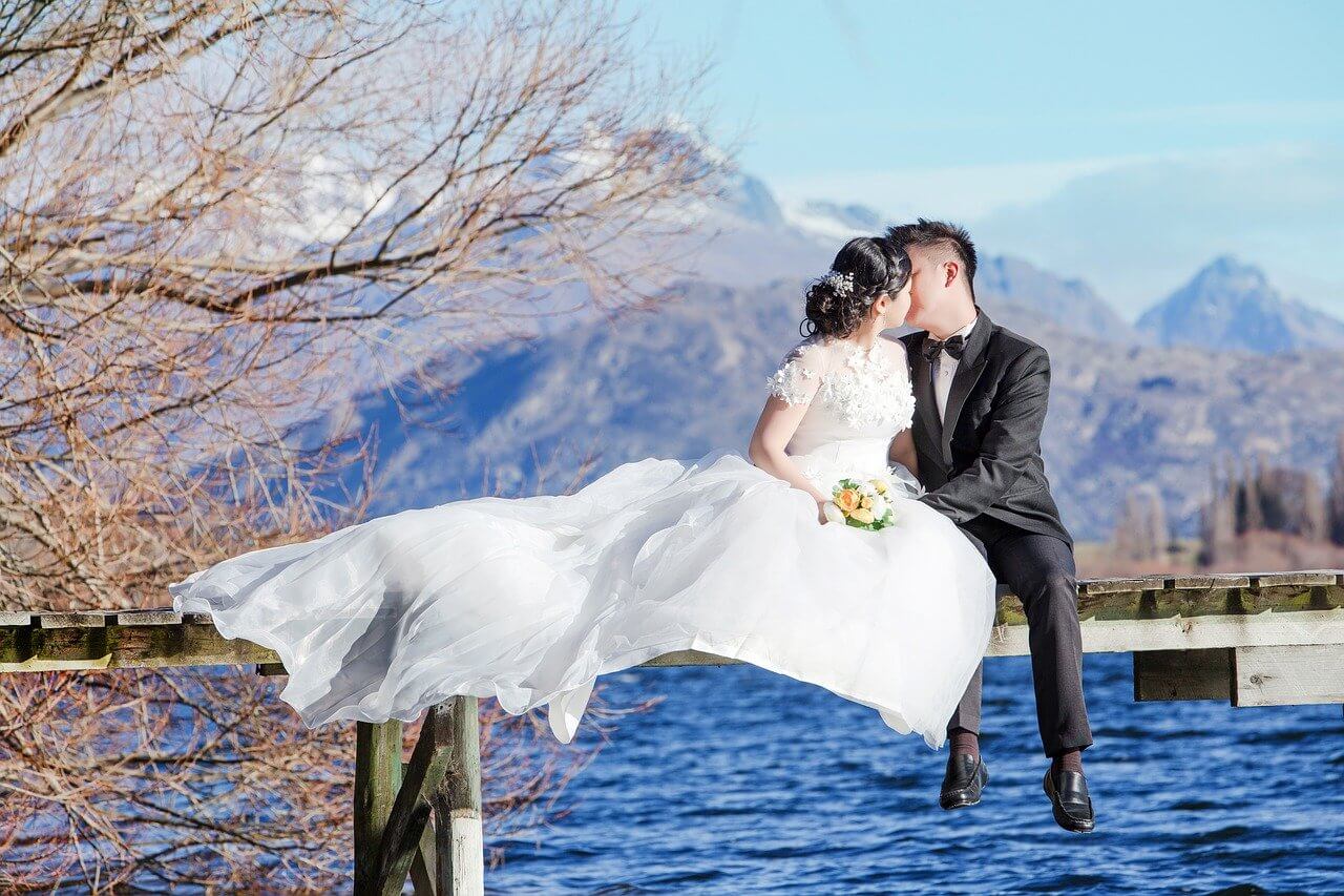 A newly married couple pose for a photoshoot in front of Queenstown's waterfront