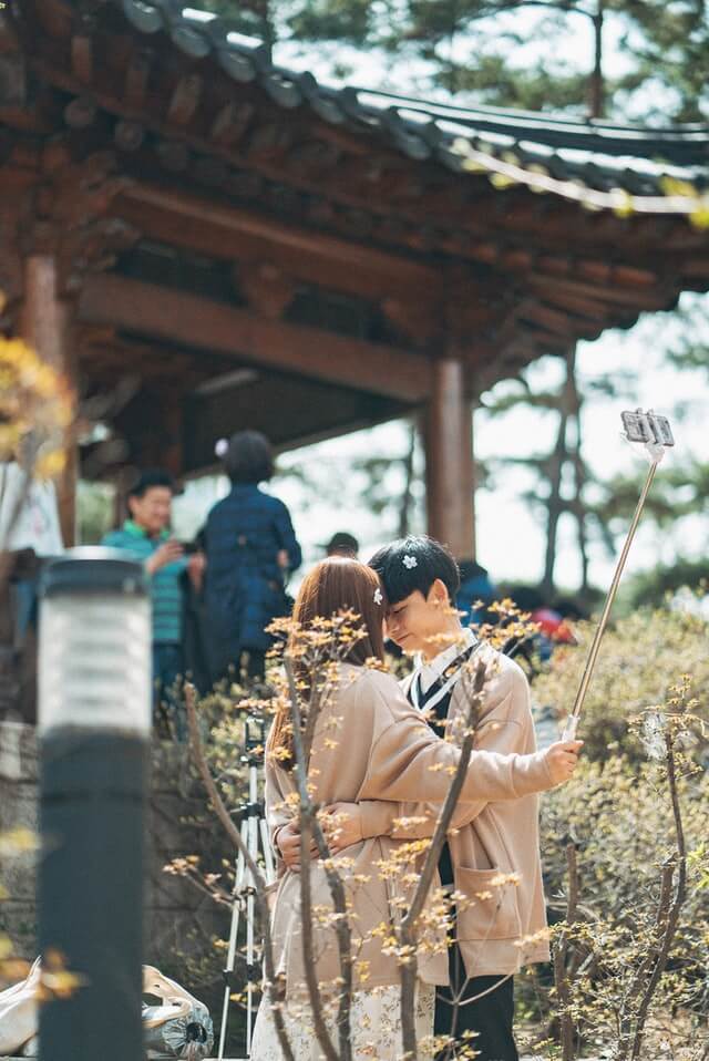 A young Korean couple embrace at the Cherry Blossom Festival in Seoul