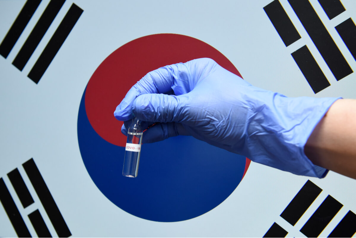 The South Korean flag with a sample COVID test tube in front
