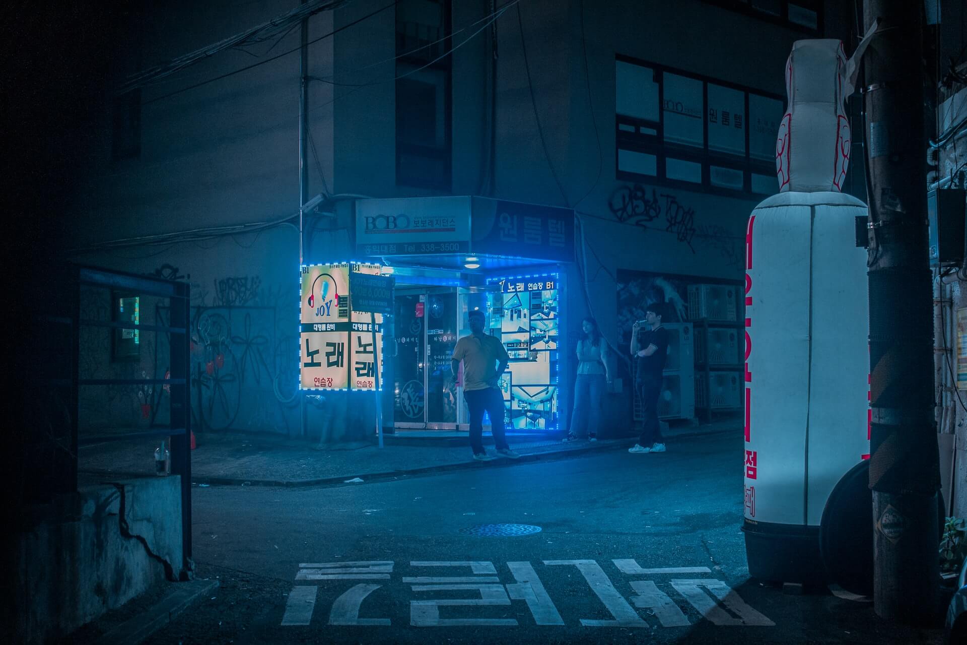 A blue-lit neon street featuring Seoul's underground nightlife