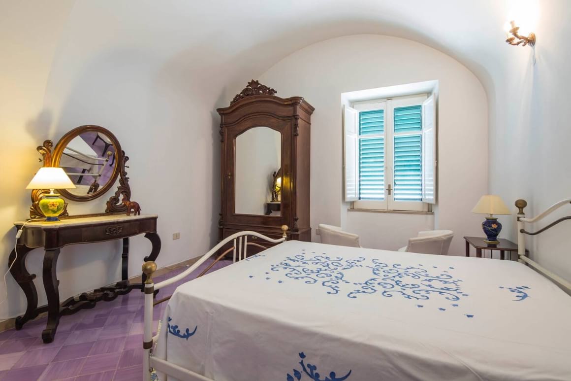 Simple bedroom with bed, dressing table and cupboard