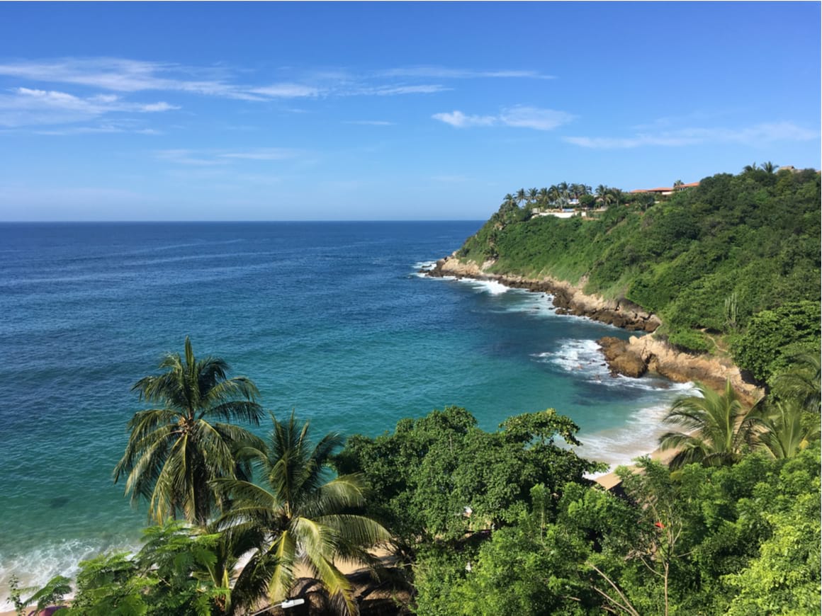 A panoramic shot of the jungle and blue beaches of Puerto Escondido, Oaxaca.