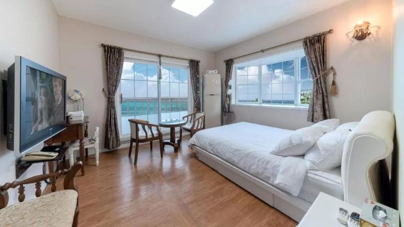 double bed looking out to sea with a private balcony Grim Resort Jeju Island