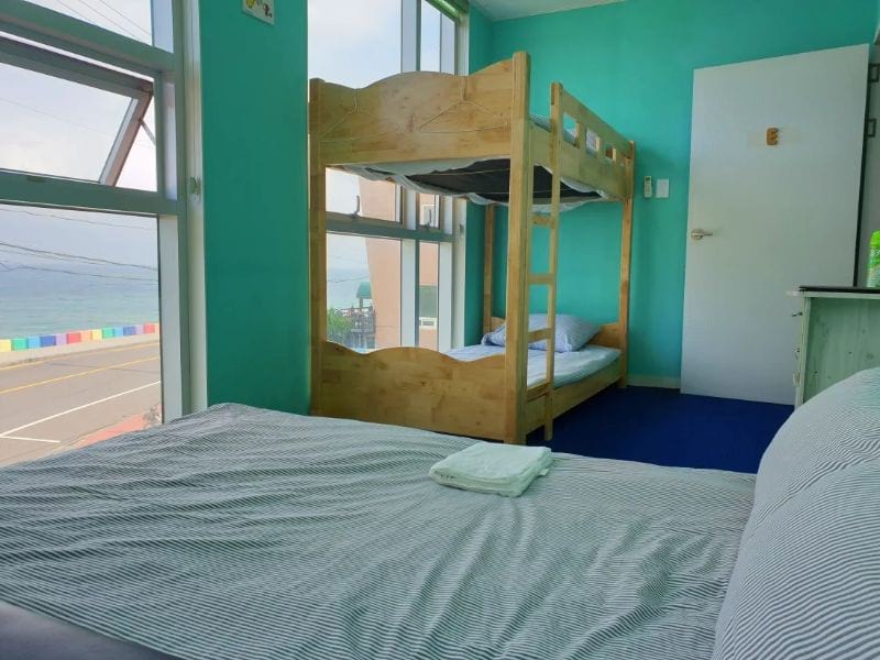 Yesjun Guest House drom room in Jeju Island with bright coloured rooms and clean bedding