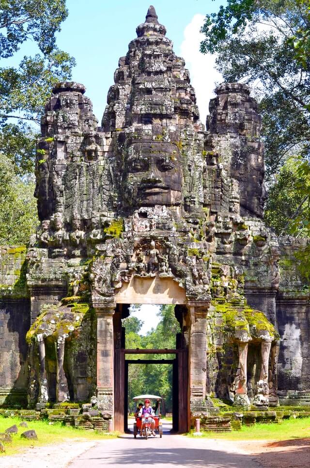 A couple of backpackers using a tuk-tuk tour guide in Angkor Wat