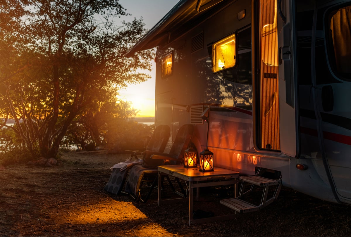 An RV camped at sunset with a perfectly packed setup of supplies and equipment