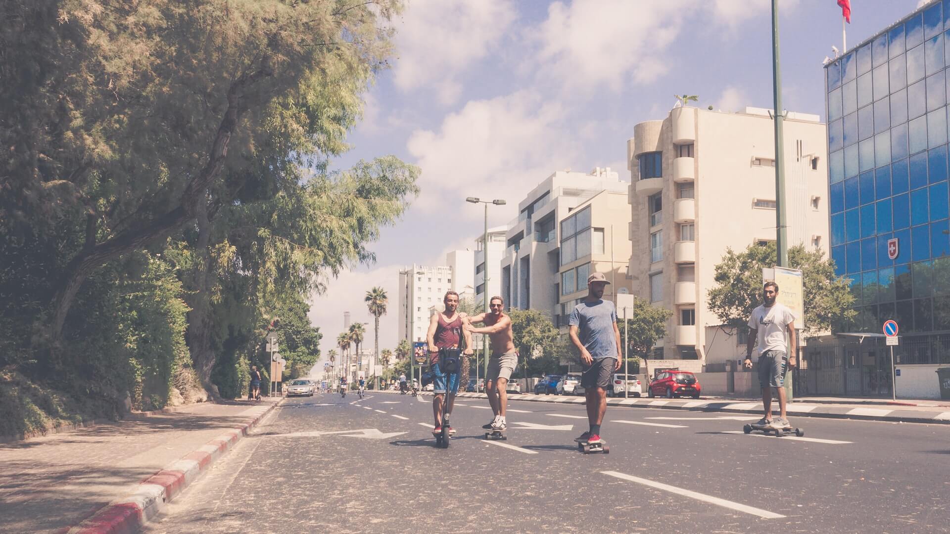 A handful of LGBT travellers skateboarding in the streets of Tel Aviv.