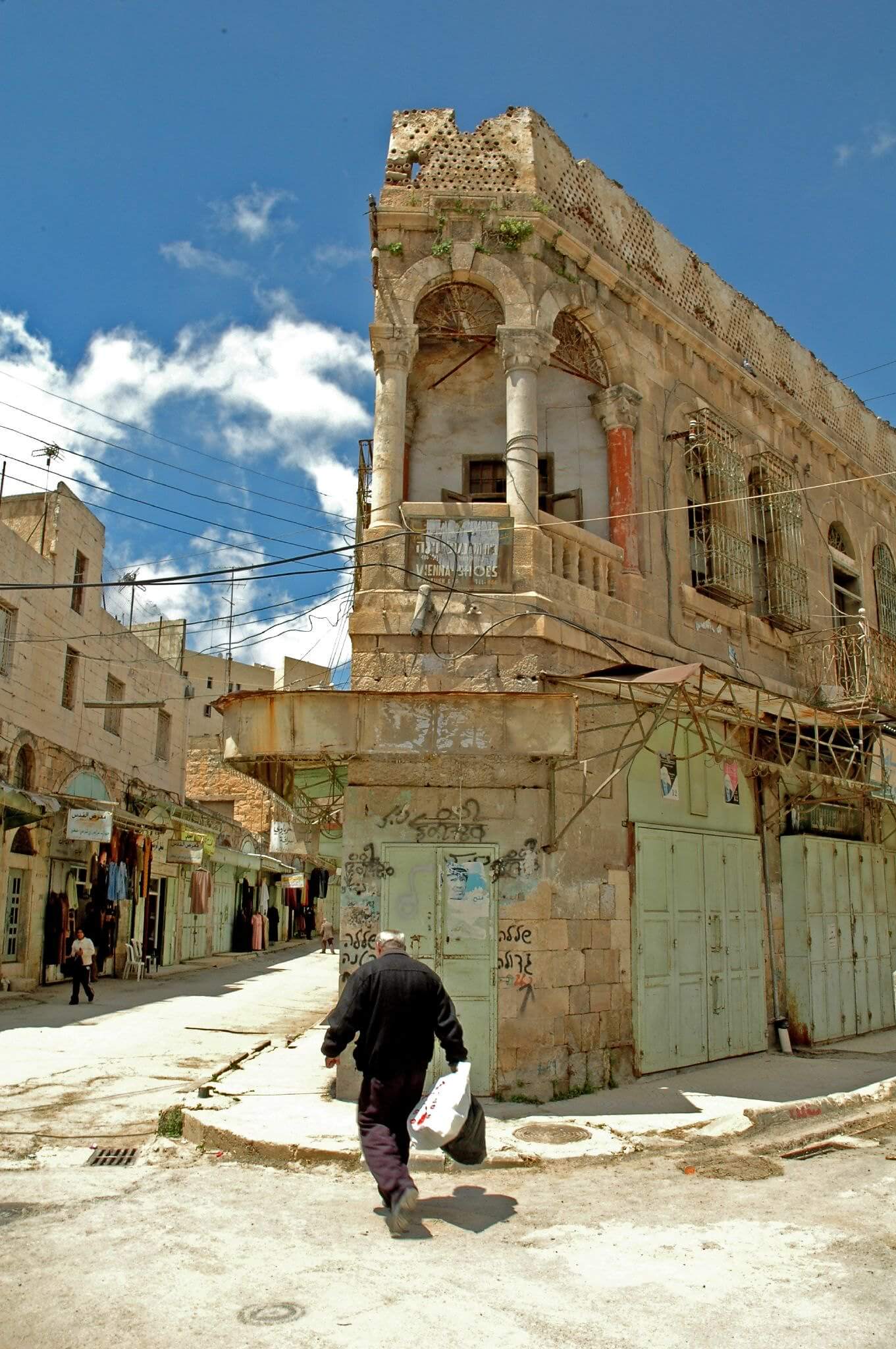 A local man walking down a rubble-filled street in downtown Hebron