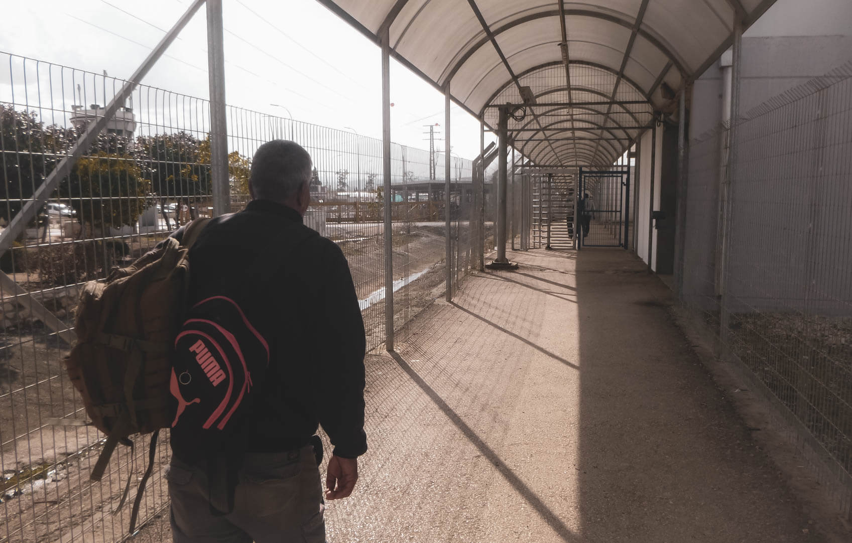 A Palestinian and backpacker enter the West Bank through a military checkpoint near Jenin