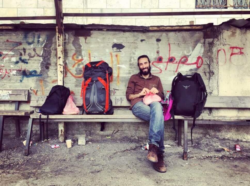 A backpacker in Israel waits for the bus in Ramallah
