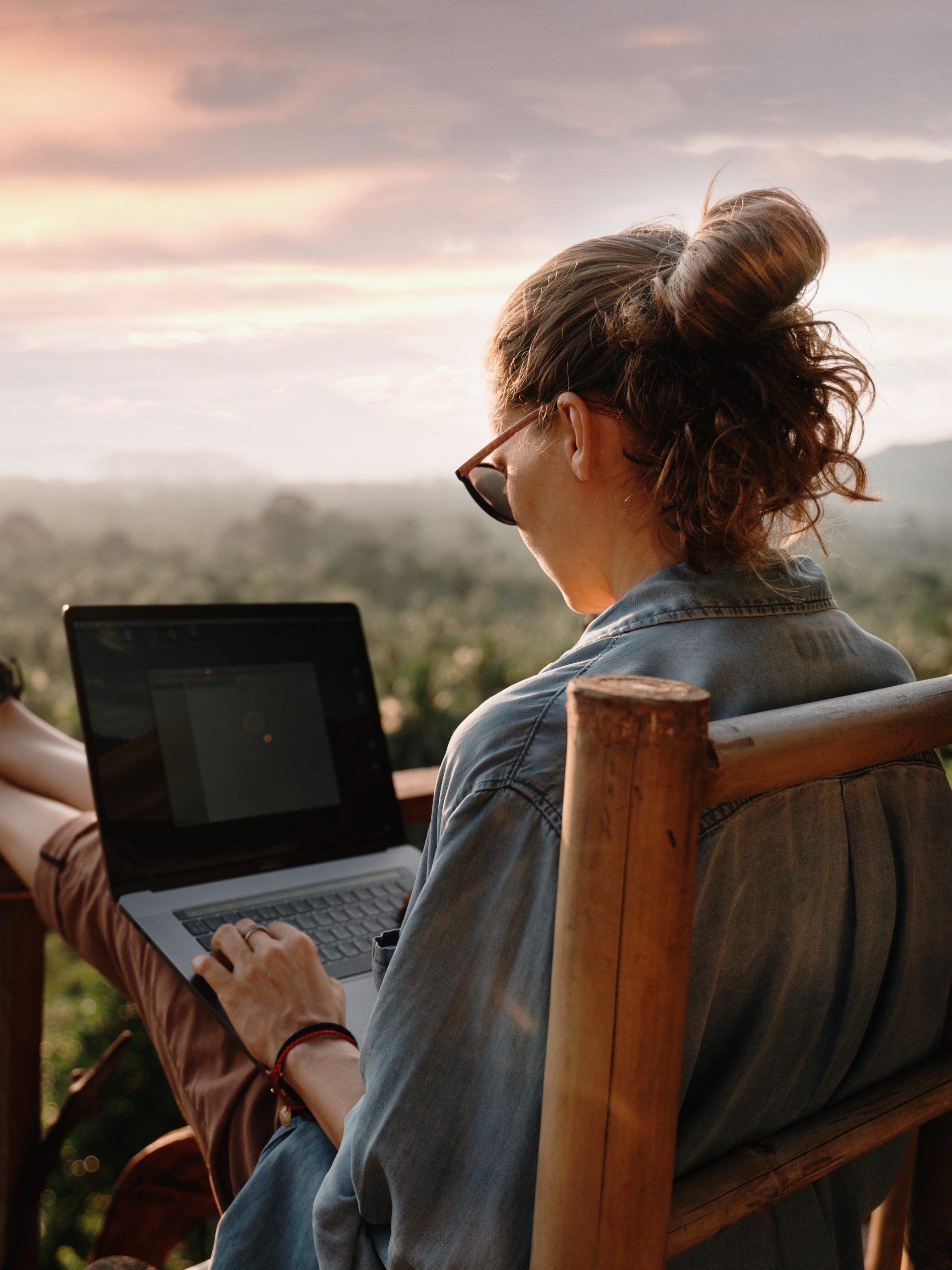 traveler working on laptop at sunset