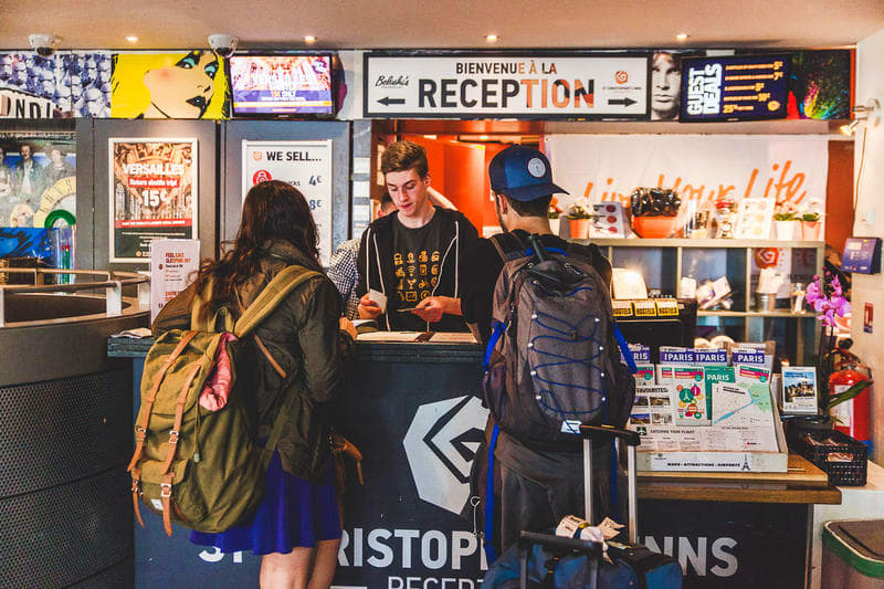 Backpackers talking about hostel etiquette with the hostel reception.