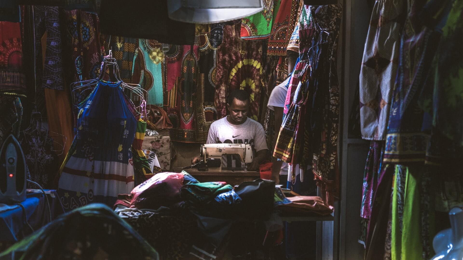 A tailor in his shop in Cape Verde working at a sewing machine