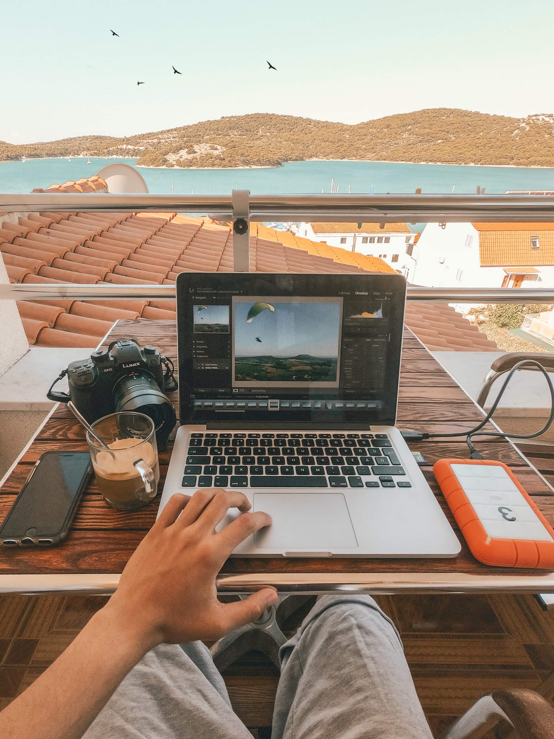 A remote worker in Croatia working at his laptop on a balcony