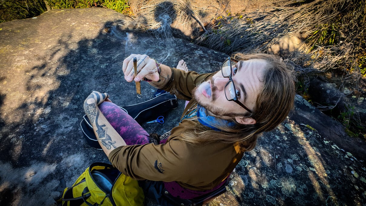 A backpacker in Tasmania smoke a joint at a popular point of interest