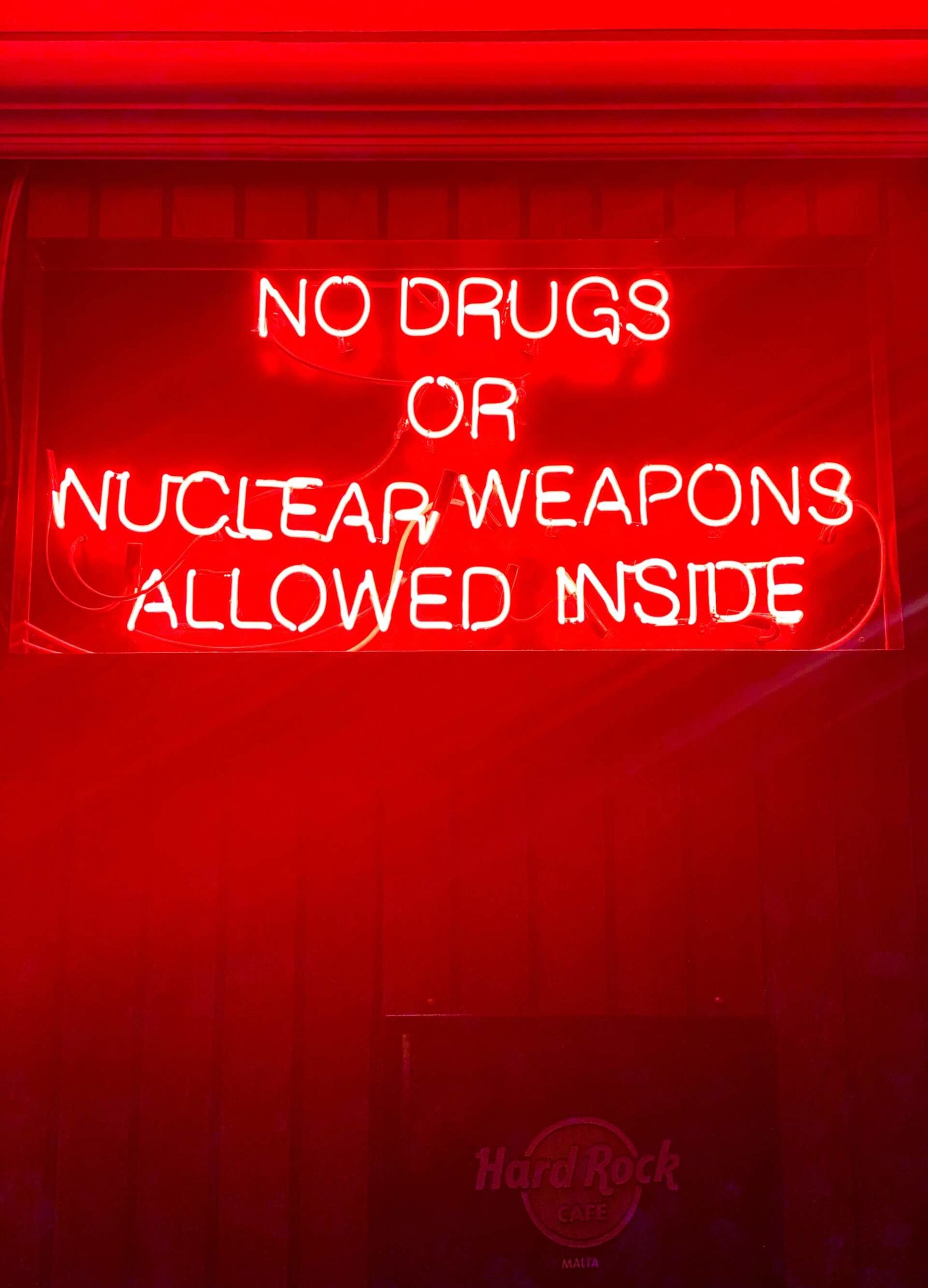 red neon sign about drugs