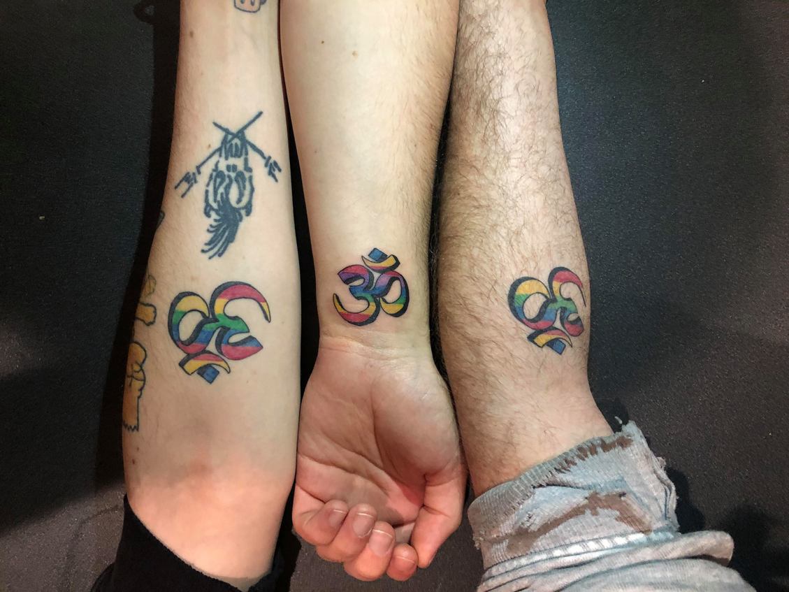 three rainbow-coloured om symbol travel tattoos