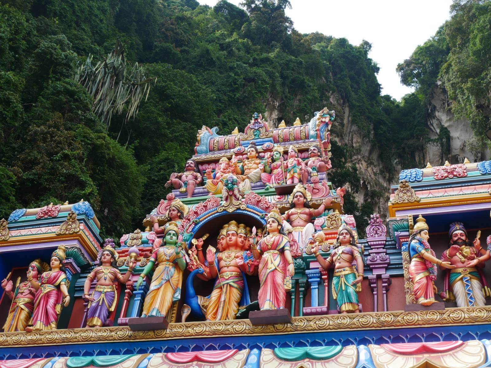 colourful figures at Batu caves in front of green mountains