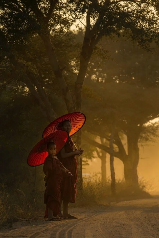 Two buddhist monks on a dirt road near a tourist town in Myanmar