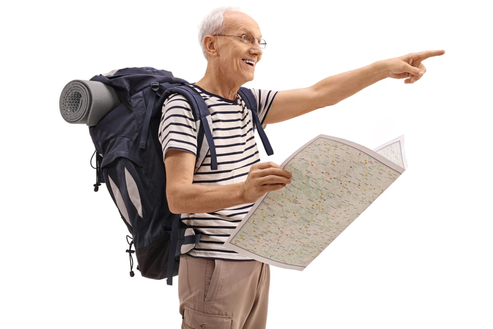 Old backpacker with a map pointing