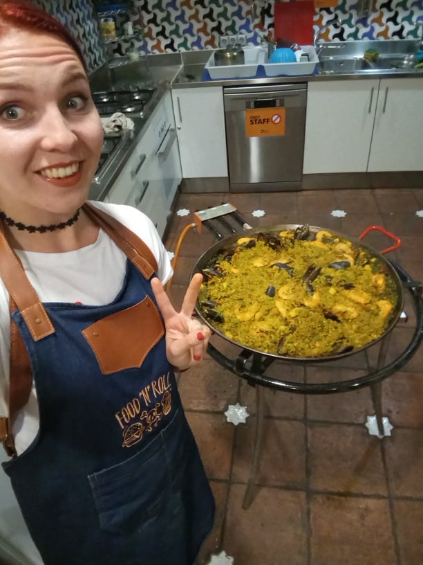 Elina taking a selfie in front of a pot of paella