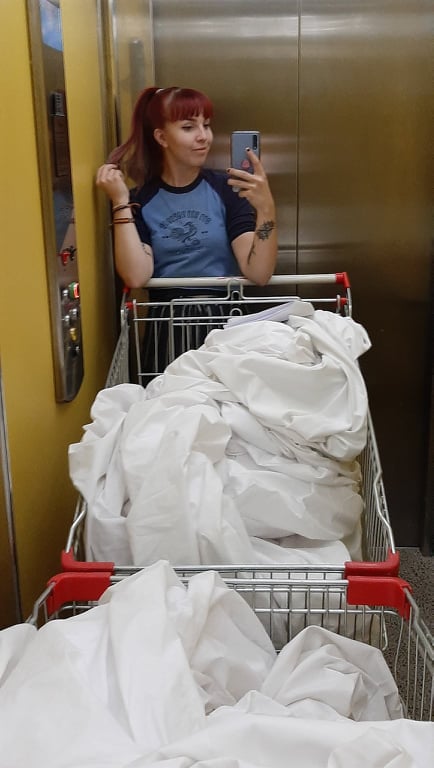 Elina with bedsheets in a hostel elevator