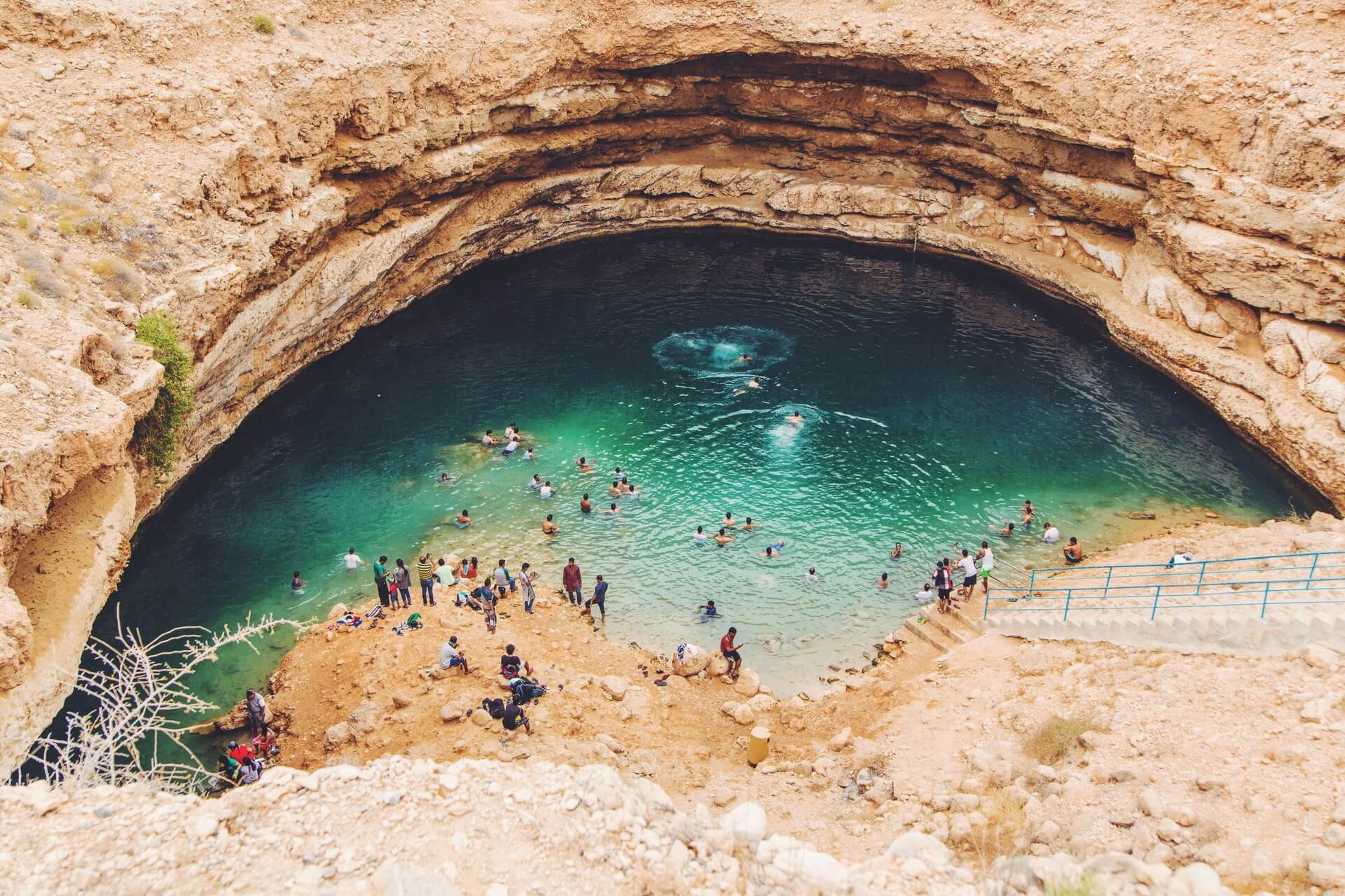 people swimming in the turquoise Bimmah Sinkhole one of the best things to do in oman 