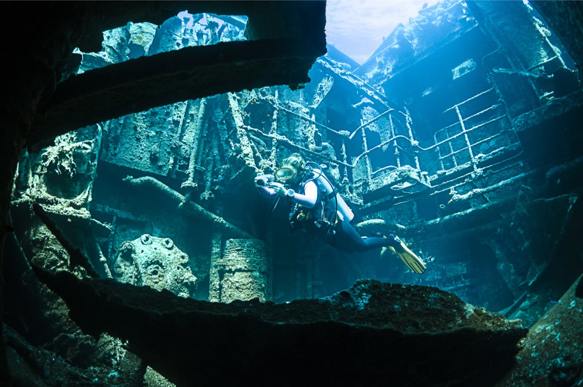 A scuba diver explores a ship wreck in Aruba