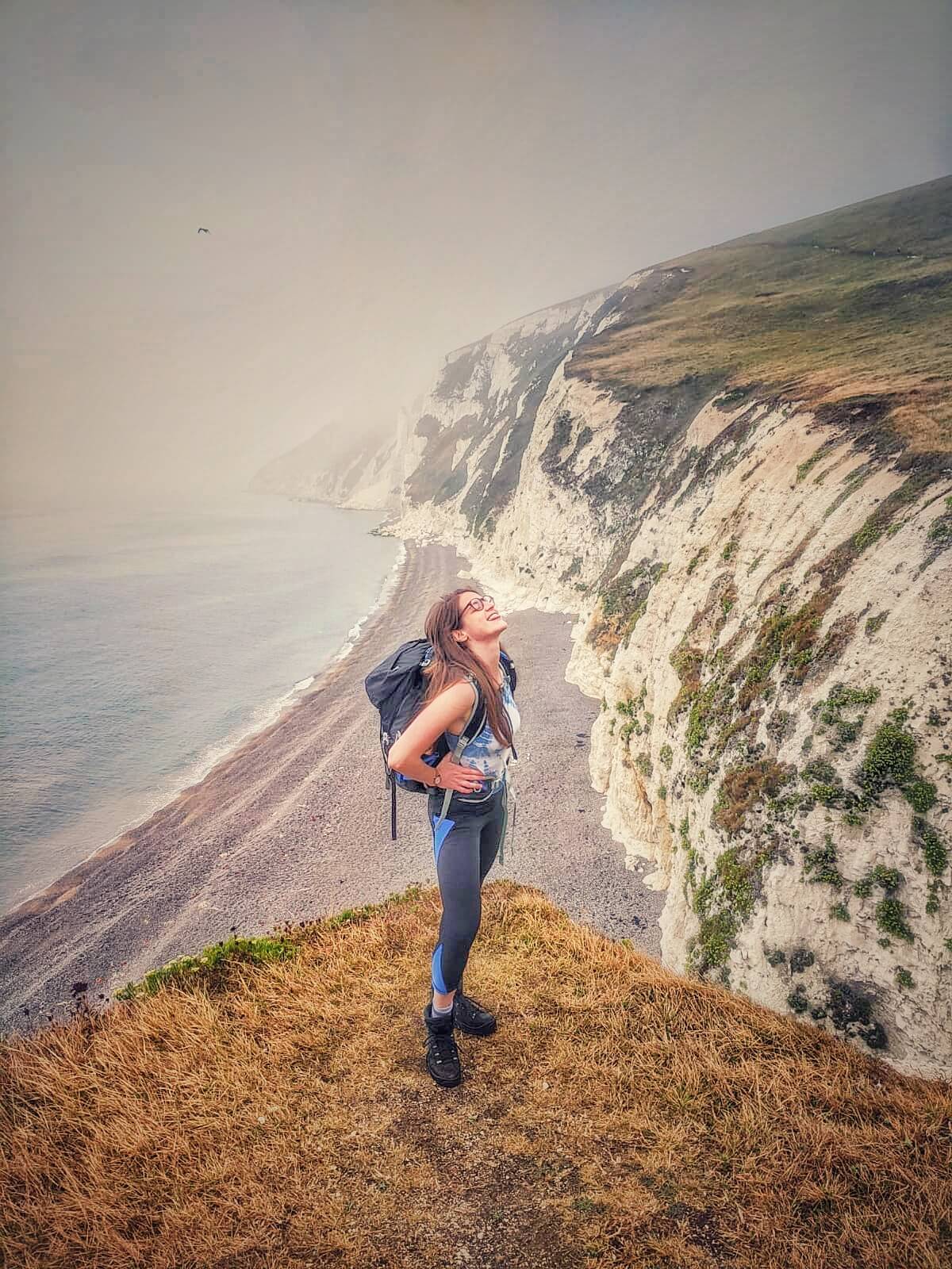 Laura hiking a bleary UK coastline