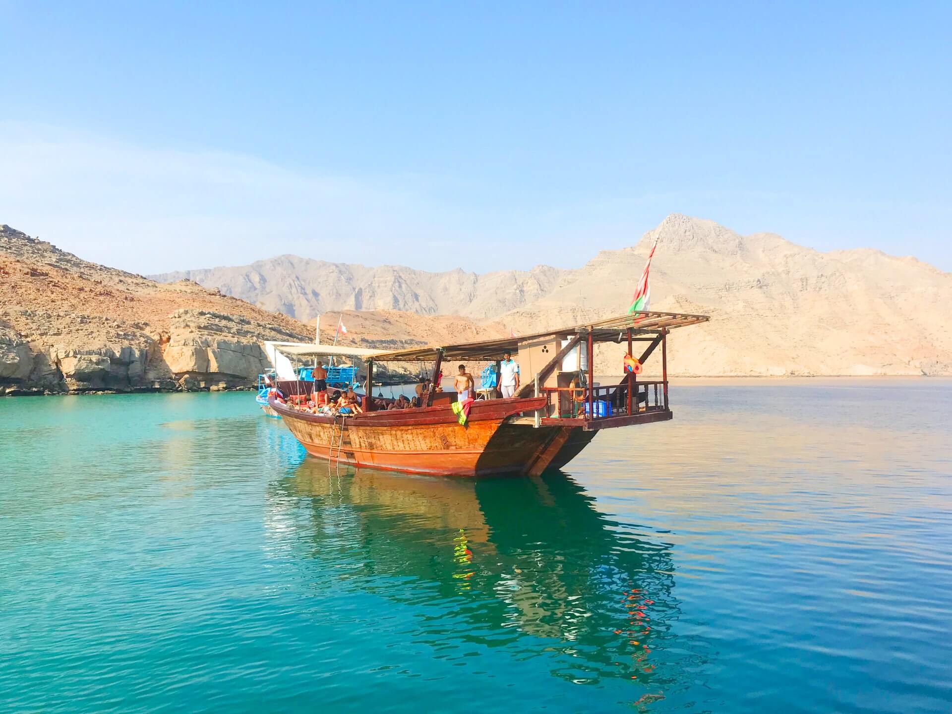 a traditional dhow boat on the blue waters of musandam in oman