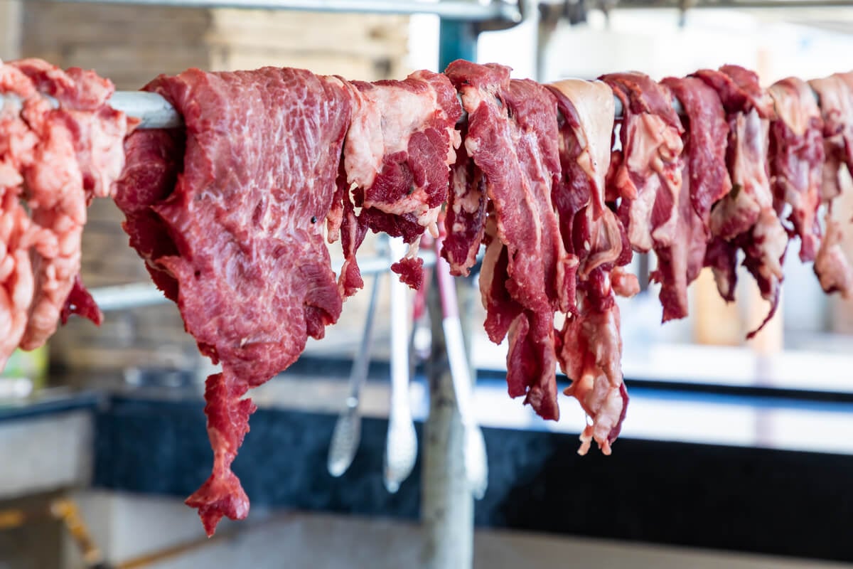 fresh camel meat hanging in a shop in oman