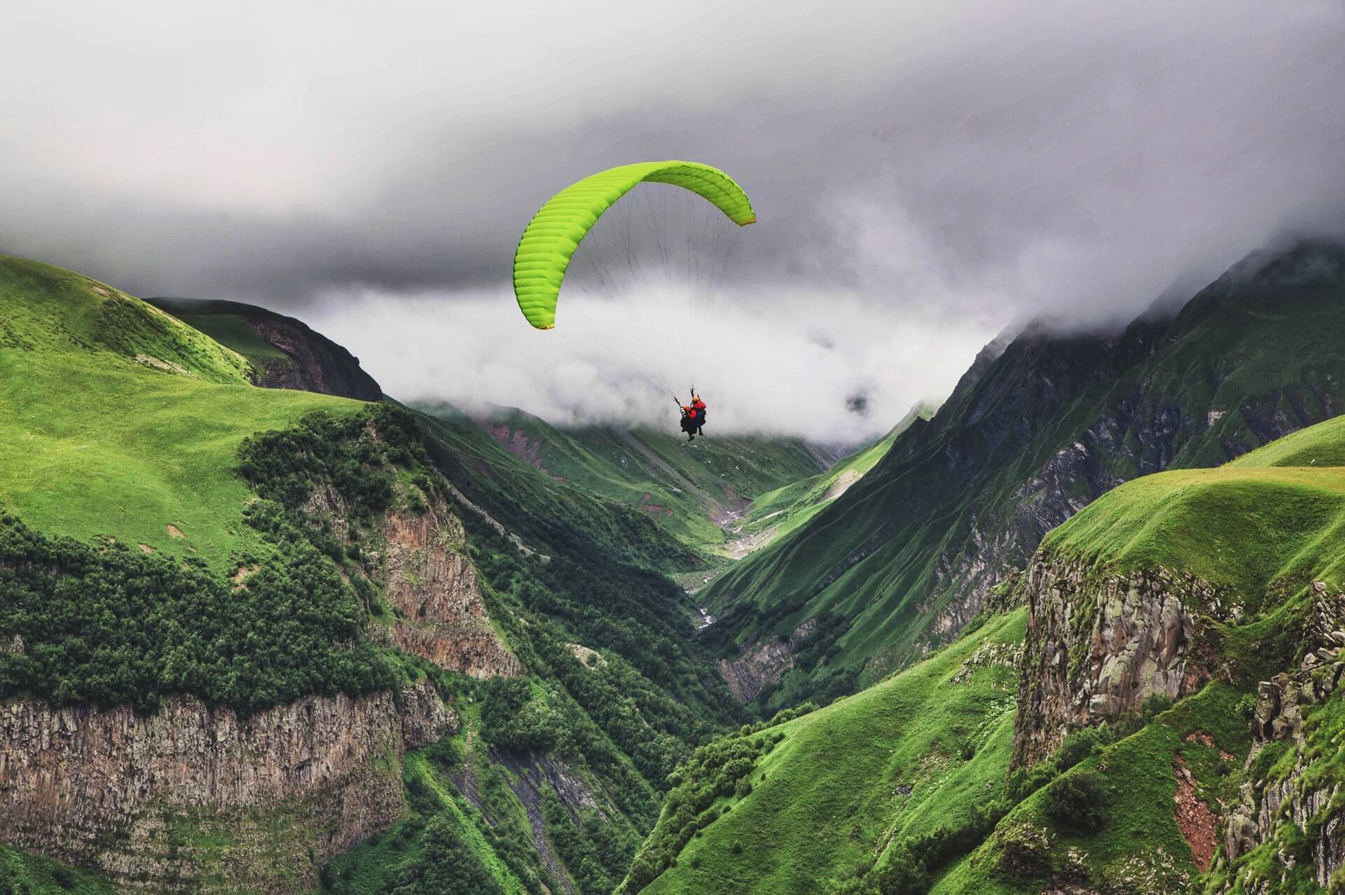 A tourist enjoying a paragliding activity somewhere green in Oman