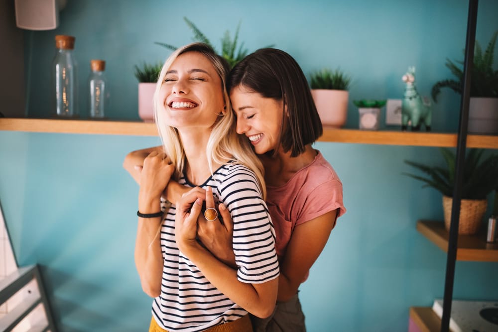 two girls laughing and hugging