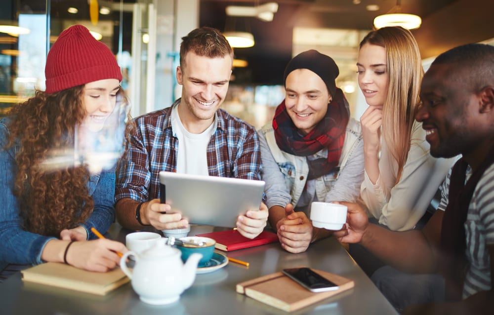 group of digital nomads gathered around a tablet