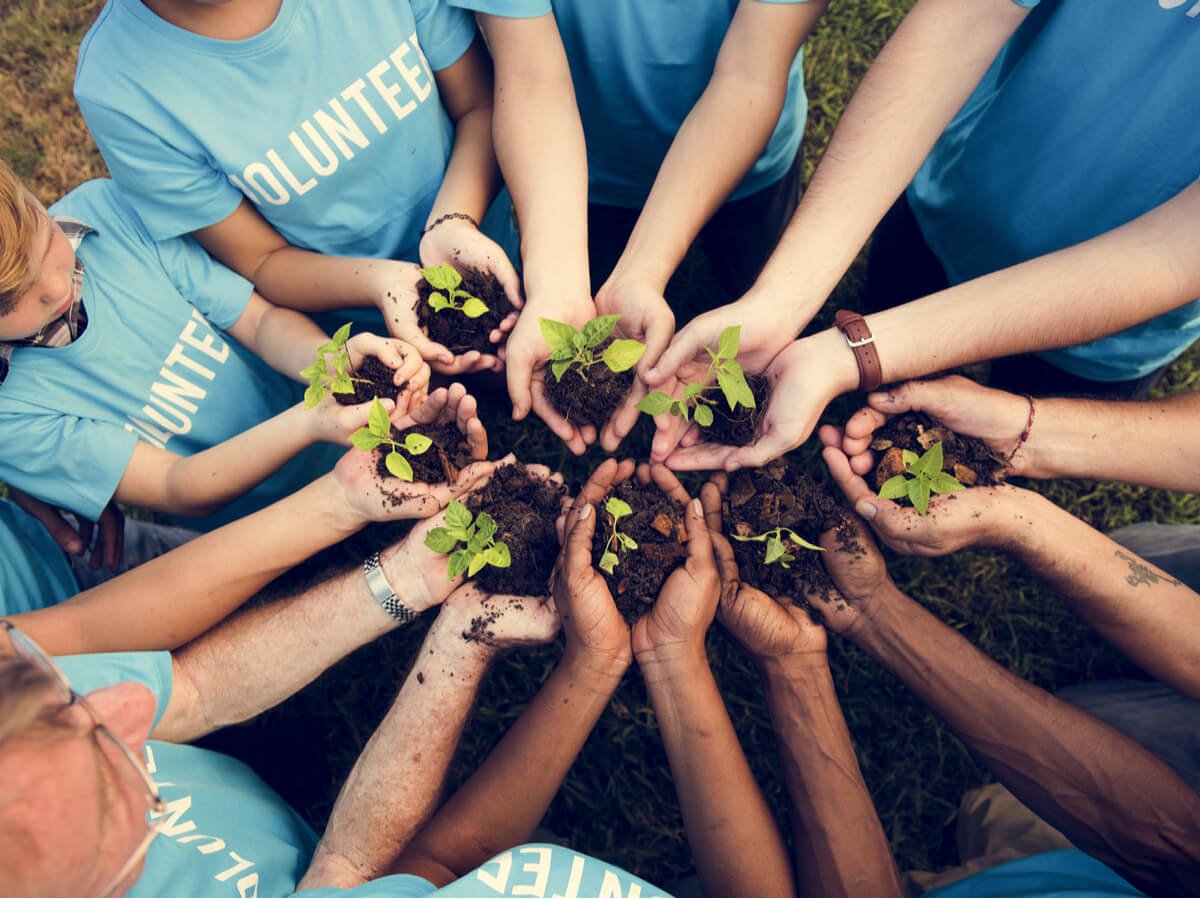 A bunch of volunteers touch hands and ignore COVID-safe procedures